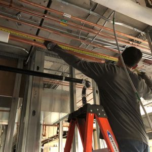 photo of employee measuring pipework in southwest washington medical center project